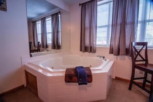 a bathroom with a bath tub with a towel on it at Bear Camp By The Night in Pigeon Forge