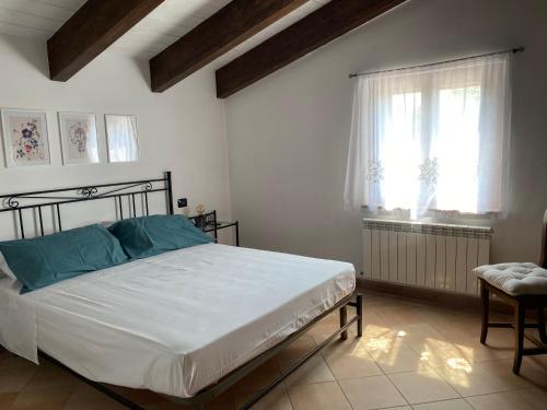 a bedroom with a bed with blue pillows and a window at Casale Col di Massa Residenza di campagna in Costacciaro