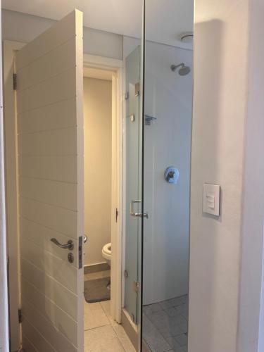 a bathroom with a toilet and a glass shower door at Ocean Dunes Bachelor Apartments in Umhlanga