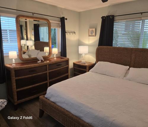 Un dormitorio con una cama y una cómoda con espejo. en Cozy island apartment, en Pompano Beach