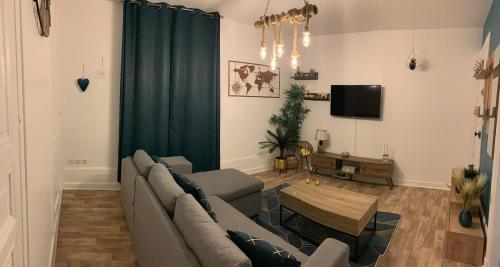 a living room with a couch and a table at Superbe studio proche centre ville in Beauvais