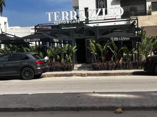 a car parked on the street in front of a restaurant at Résidence les Fatimides in El Aouina Station