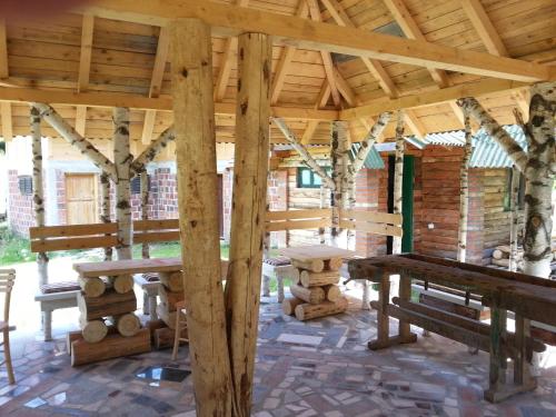 a wooden pavilion with picnic tables and trees at Staparski Sorrento in Užice