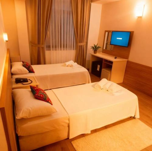 a hotel room with two beds and a television at Çelik Crown Hotel in Trabzon
