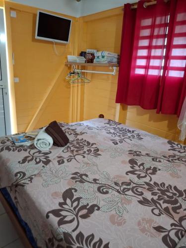 a bedroom with a bed with a black and white blanket at Pacifique un Bungalow charmant pour deux, entre mer et nature in Saint-Louis