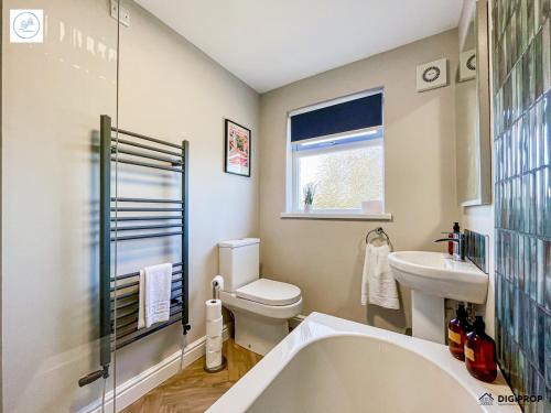 Un baño con bañera, inodoro y lavabo. en Alder House - Dowlais, en Dowlais