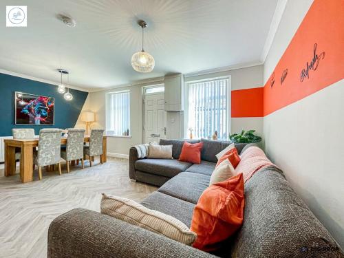 a living room with a couch and a dining room at Alder House - Dowlais in Dowlais