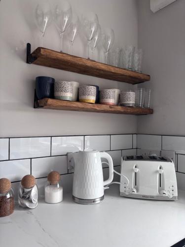 a kitchen counter with a toaster and a tea kettle at Alder House - Dowlais in Dowlais