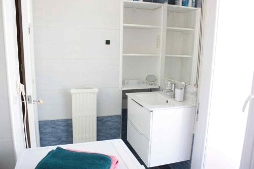 a white bathroom with a sink and a mirror at Le Cocon Niçois Studio Cozy et Lumineux avec Parking in Nice