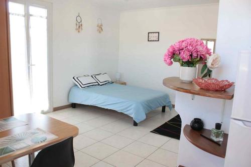 a room with a bed and a table with flowers at Le Cocon Niçois Studio Cozy et Lumineux avec Parking in Nice