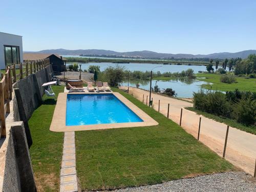 a swimming pool with a view of a river at Casa con vista lago Rapel in Las Cabras