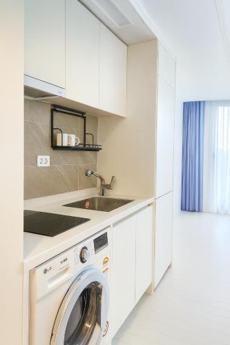 a kitchen with a washing machine in a white kitchen at 부산 엘스테이 호텔 레지던스 EL STAY Busan Long Stay Hotel Residence l 아르떼20 OFF짚라인30 OFF스릴10 OFF 할인 in Busan
