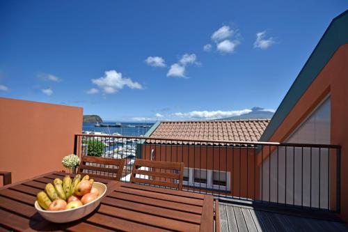 a bowl of fruit on the balcony of a house at Casa da Baía - Guest House in Horta