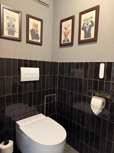 baño con aseo y 3 cuadros en la pared en Das Genner - Suite am Bisamberg, en Klein-Engersdorf