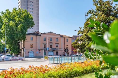 a building on a city street with flowers in front at The Central Rock Inn camere con bagno privato self check in in Piacenza