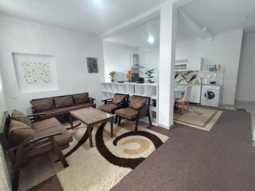 una sala de estar con un sofá y una mesa en White Apartment, en Prizren