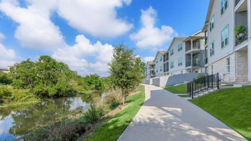 a walkway in front of apartment buildings with a canal at Pleasant apartment in Austin in Leander