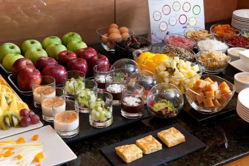 a buffet filled with different types of fruit and desserts at NH Madrid Chamberí in Madrid