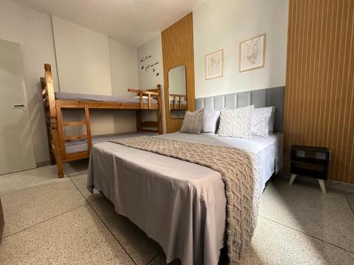 ein Schlafzimmer mit einem Bett und einem Etagenbett in der Unterkunft Boqueirão: 50m do mar e perto de tudo! in Praia Grande
