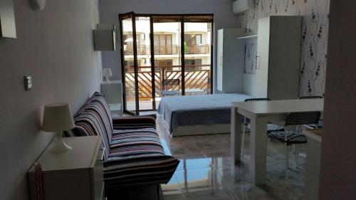 a bedroom with a bed and a table and a desk at Apartments Resort BG in Primorsko