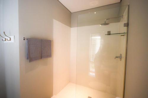 a bathroom with a shower with a glass door at Calm Oasis in the heart of the Karoo in Prince Albert