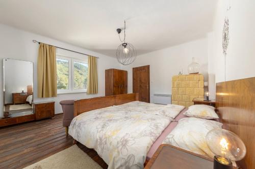 a bedroom with a large bed and a window at doLodge homestead in the Kolpa River canyon in Stari Trg ob Kolpi