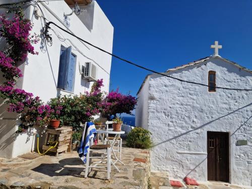 una iglesia con una mesa y sillas y una cruz en Peppermint Bay, en Skopelos Town