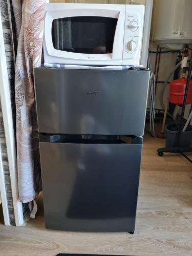 a microwave sitting on top of a refrigerator at Le studio à la campagne in Saint-Gobert