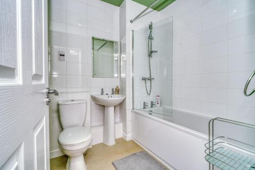 a white bathroom with a toilet and a sink at Stylish 2-bedroom home in Salford - 5 guests in Manchester