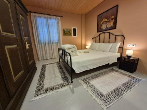 a bedroom with a bed and a window and two rugs at Apartment Rustico in Ancient Epidauros