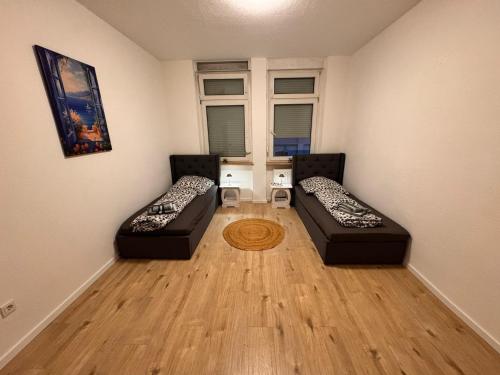 a living room with two beds and a wooden floor at A&V Apartments Hemer Nähe Lungenklinik 2 in Niederdorla