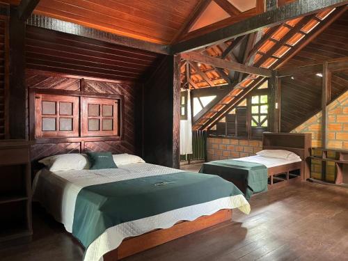 a bedroom with two beds in a room with wooden ceilings at Casa Bem-Te-Vi | Alter do Chão in Alter do Chao