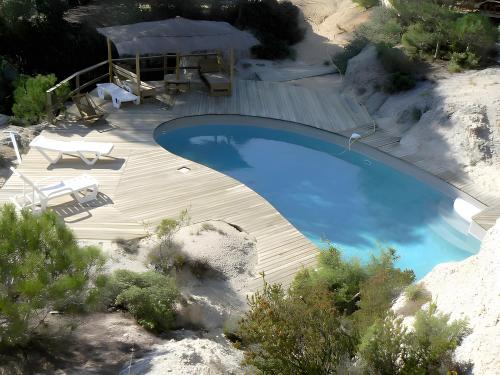 an overhead view of a swimming pool with a wooden deck at Le Sabel - Cabanon in Mourèze