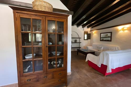 a bedroom with a large wooden cabinet with dishes in it at Alojamientos Nacarum in El Palmar