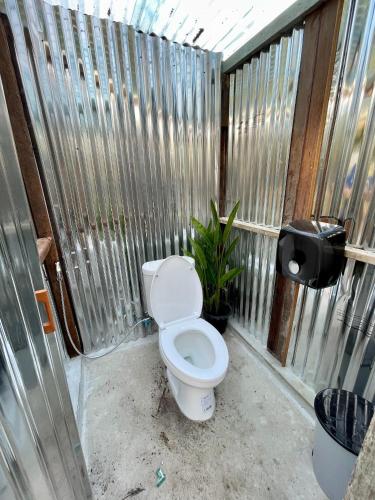 a bathroom with a toilet in a fence at มีสุข ฟาร์มสเตย์ in Lop Buri