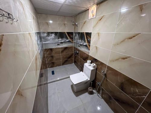 a dirty bathroom with a toilet and a sink at Lunar Mirage Camp in Wadi Rum