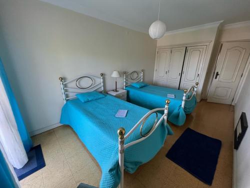 a bedroom with two beds with blue sheets at Superb Position Over the River Historical Center Tomar in Tomar