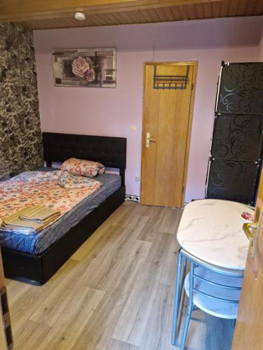 Un dormitorio con una cama y una mesa y una puerta. en Zimmer 3 mit eigenem Bad & Eingang nähe Barmstedt Elmshorn, en Bokholt-Hanredder