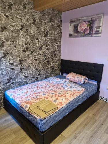 una cama en una habitación con una pared de piedra en Zimmer 3 mit eigenem Bad & Eingang nähe Barmstedt Elmshorn, en Bokholt-Hanredder