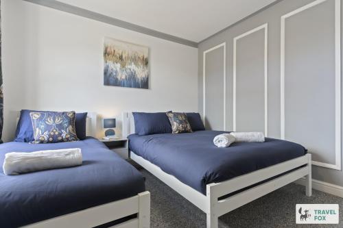 a bedroom with two beds with blue sheets at Mia's House: Park view +Parking in Nottingham