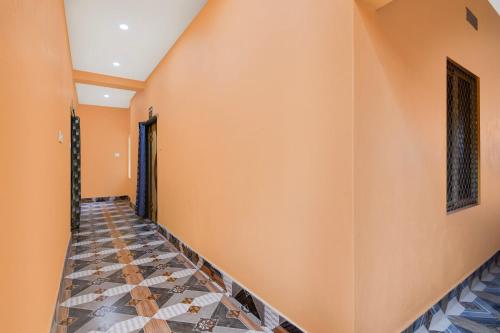 a hallway with orange walls and a tiled floor at OYO Flagship Hotel O Mo Kudia in Puri