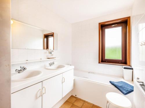 a white bathroom with two sinks and a mirror at La Paix in Sint-Idesbald