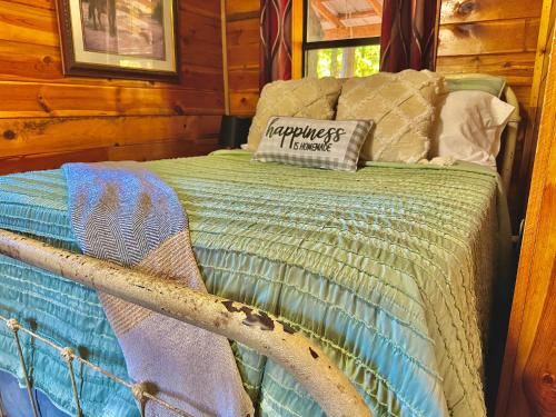 Una cama en una cabaña de madera con una almohada. en Mossback, en Wright City