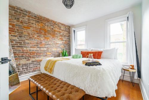 a bedroom with a bed and a brick wall at Prime Location Top Rated Clean Parking Free! in Columbus