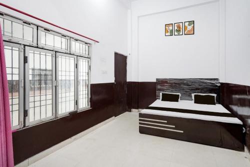 Un dormitorio con una cama en una habitación con ventanas. en HOTEL O SP GRAND Sidhauli, en Mahmūdābād