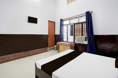 un dormitorio con una cama y una ventana en HOTEL O SP GRAND Sidhauli, en Mahmūdābād