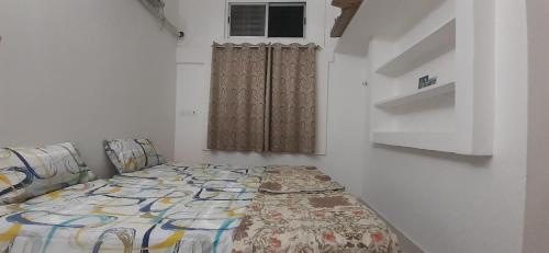 a bedroom with a bed and a window at Paripuranam in Tiruvannāmalai