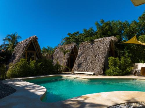 a resort swimming pool withitionalitionalitional dwellings with blue water at Villa Privada Merkaba Pxm in Brisas de Zicatela