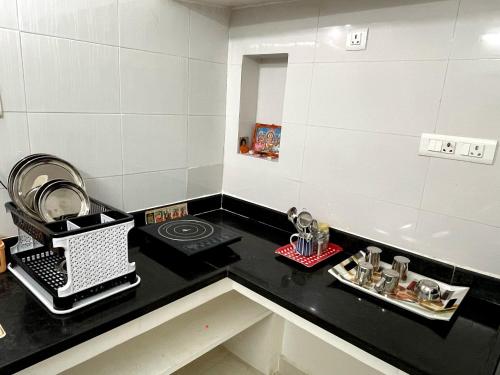 a kitchen with a black counter top and a sink at Paripuranam in Tiruvannāmalai