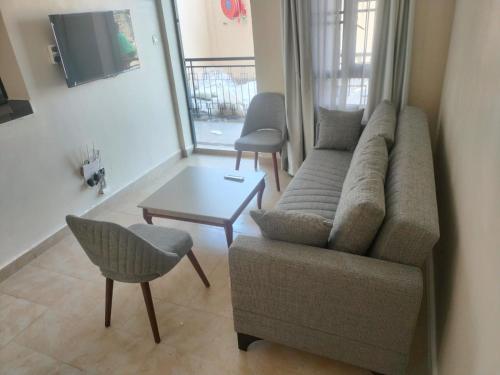 MbitaにあるLakeview Apartments - Cozy Greyのソファとテーブルのあるリビングルーム